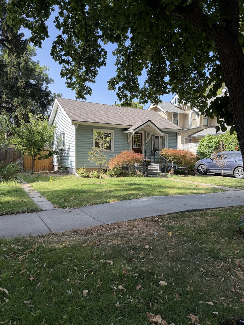 North and east sides, viewed from the southwest. Opposite front oblique showing the cottage depth and driveway beside the neighboring house.