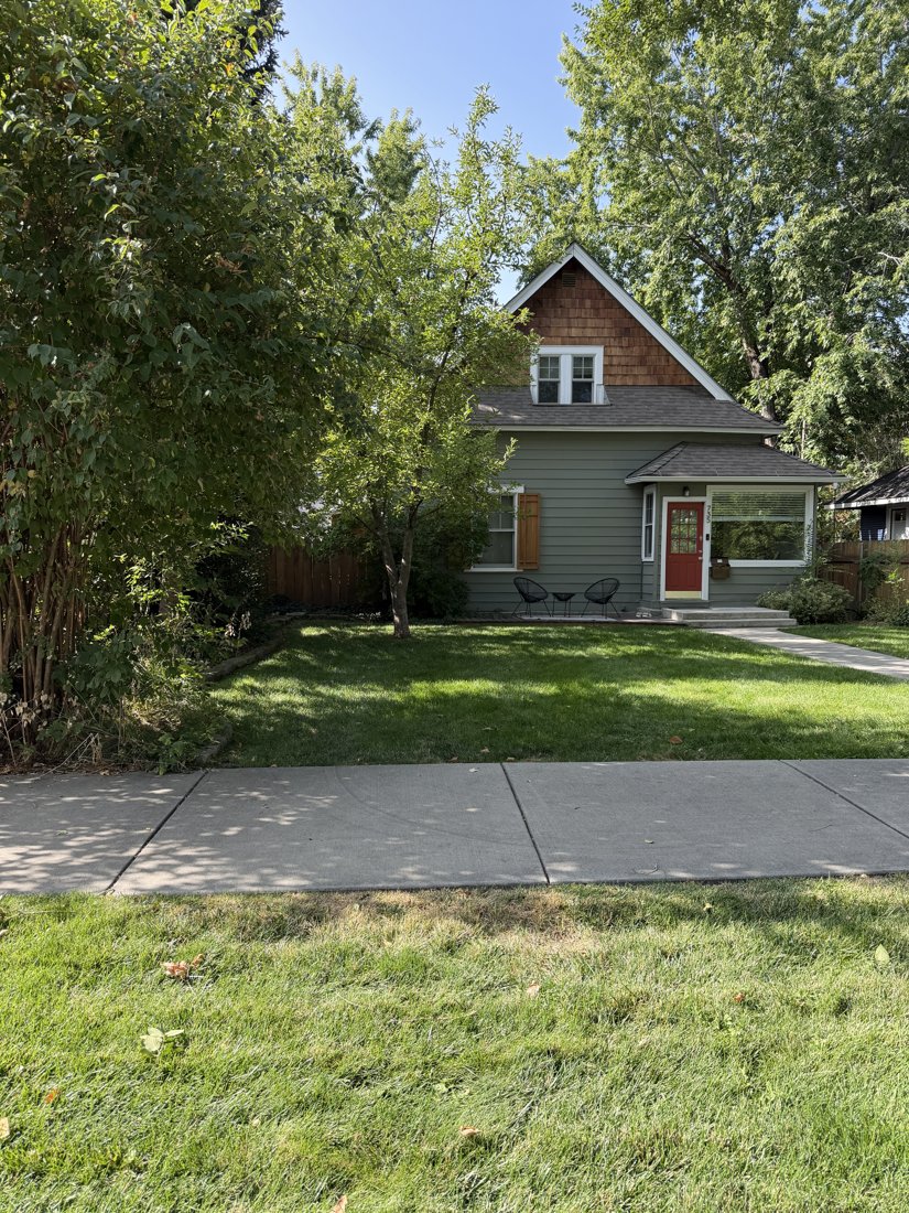 North side, viewed from the south. Oblique front view of the gabled house and entrance projection within its planted setback.
