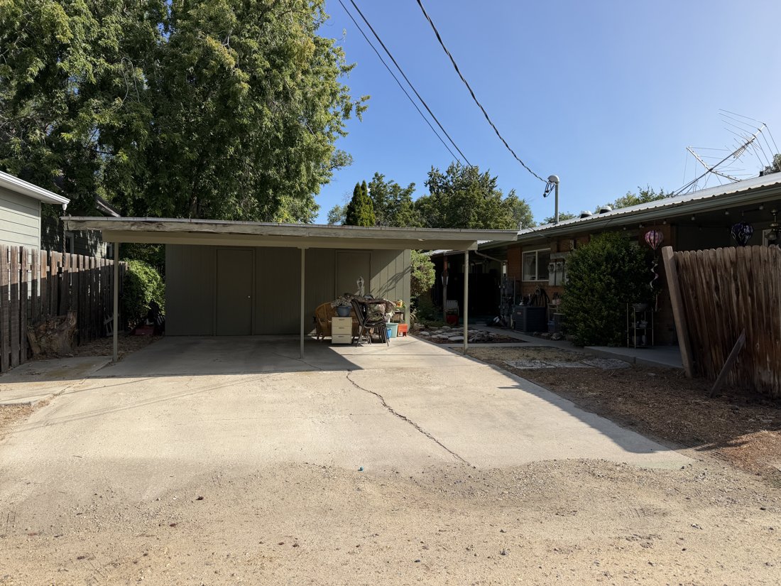 South side, viewed from the north. Open carport and paved court behind the brick residential group.