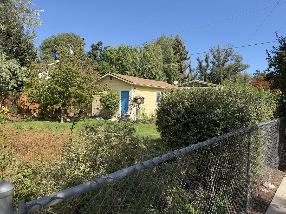 South side, viewed from the north. Garden-side gabled outbuilding with pedestrian door and side window; may be the opposite end of the garage in IMG_2875–2876.