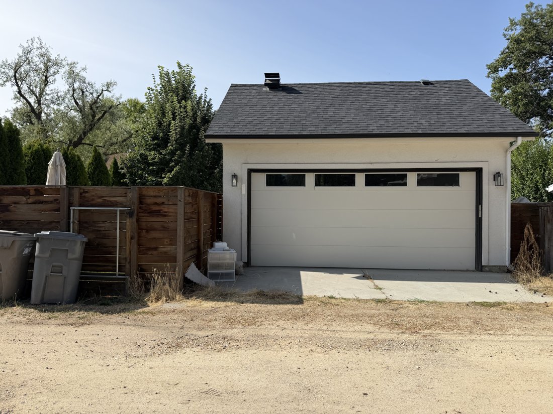 North and east sides, viewed from the southwest. Alley door elevation of the garage with a broad sectional door and upper lights.